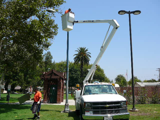Person changing a light at a park
